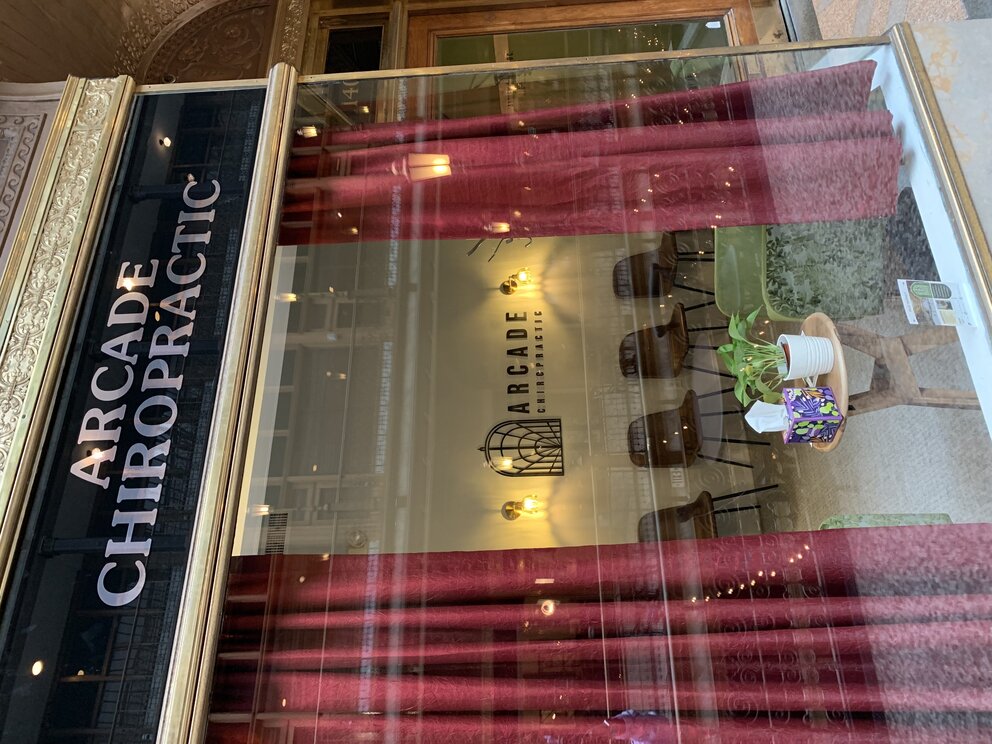 a store front with red curtains and a sign