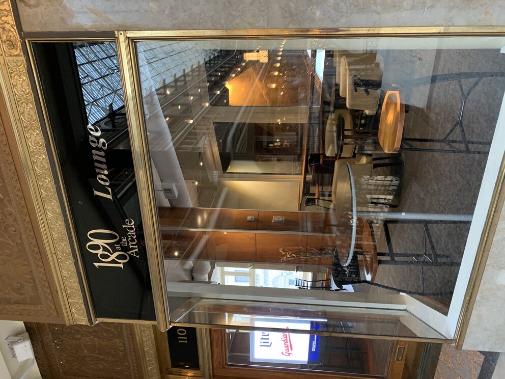 a glass door with a sign and a table and chairs outside